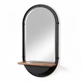 Espejo moderno con estante de madera y marco negro, diseño ovalado.
